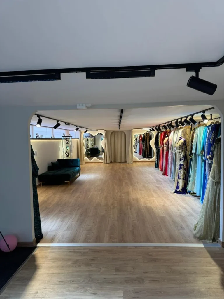 Entrée du showroom Majestia à Clichy, portants et canapé en velours vert